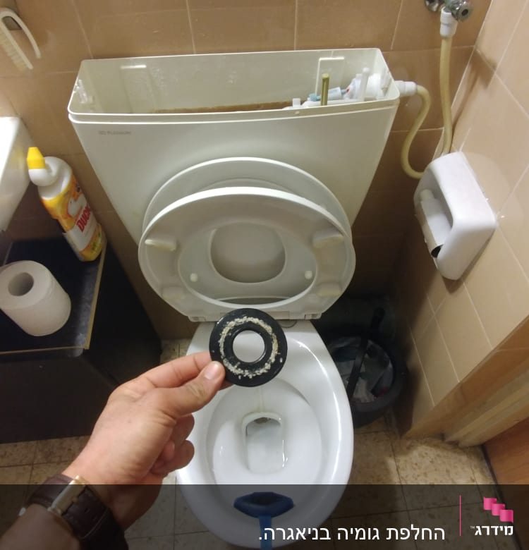 יד מחזיקה אטם גומי מול אסלה פתוחה